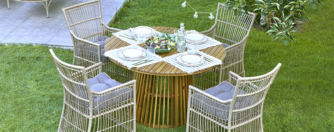 Masă rotundă de grădină și patru scaune de grădină pe gazon
