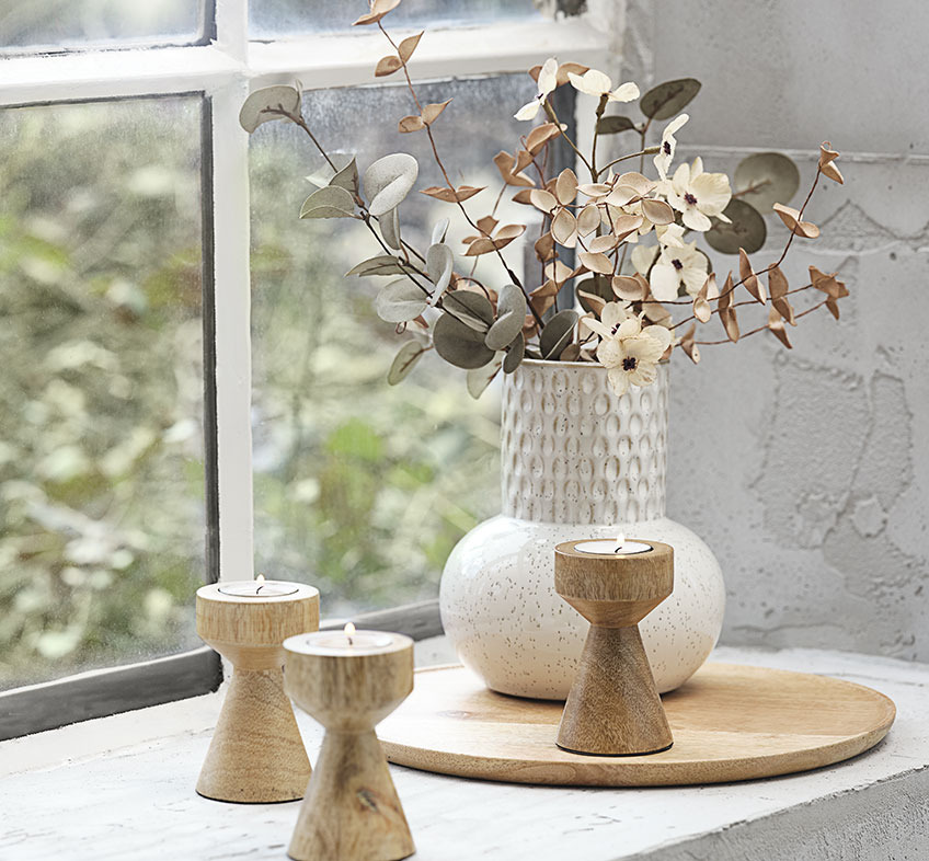 Vaza in relief bej deschis sau alb cu flori artificiale si suporturi din lemn pentru lumanari