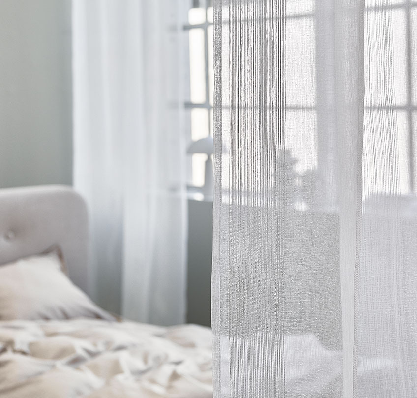 Perdele albe folosite pentru a separa o zonă de dormit de o cameră de zi