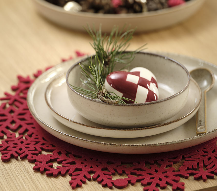Servet de masa roșu cu farfurii, bol și decoratiune