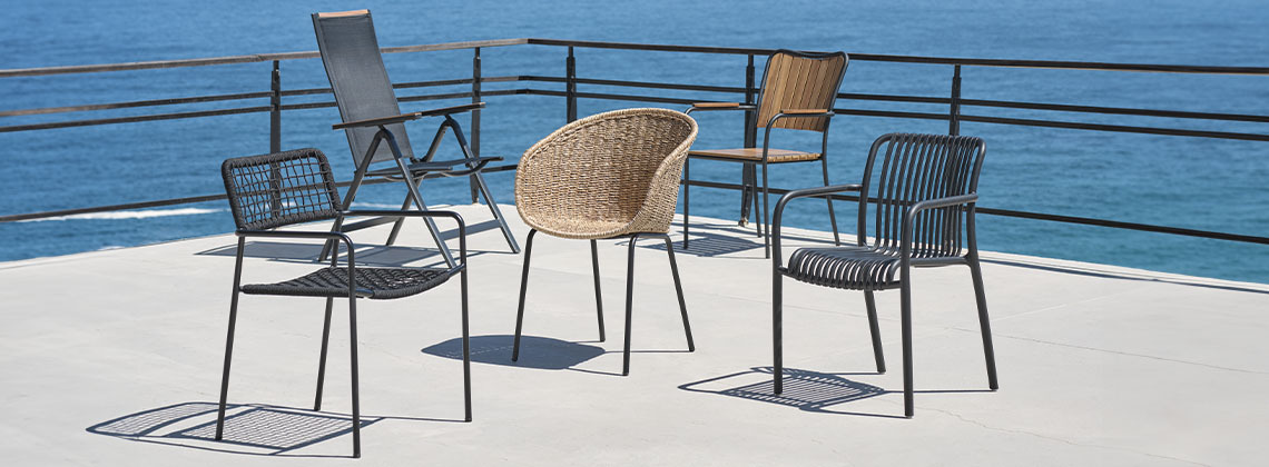O selecție de cinci scaune de grădină pe terasa lângă mare