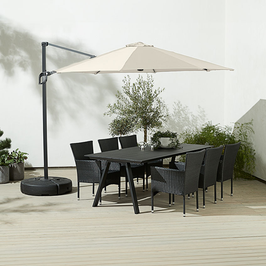 Umbrelă de soare mare, pătrată, suspendată deasupra mesei în aer liber cu scaune de grădină