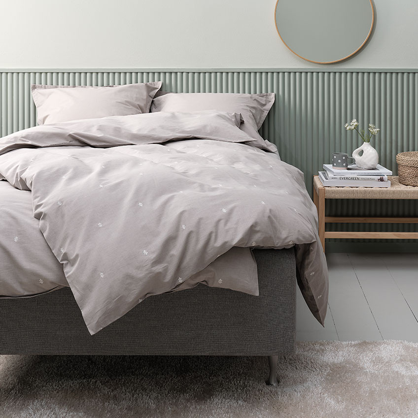 Set lenjerie de pat gri deschis din bumbac, inclusiv fată de pernă pe patul din dormitor