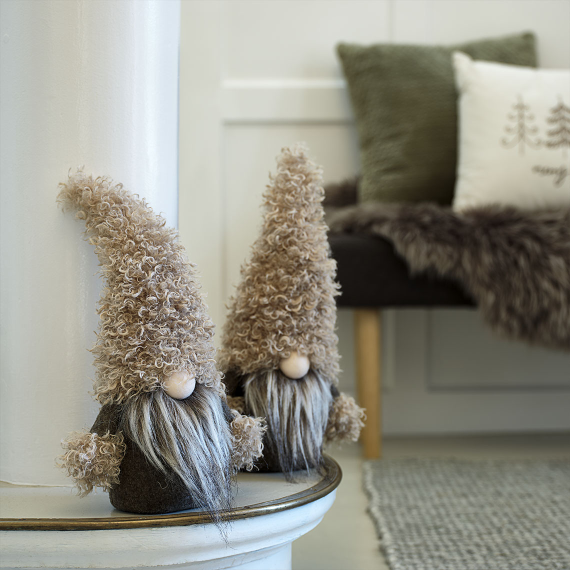 Mici spiriduși decorativi de Crăciun în nuanțe de verde și maro pe bufet