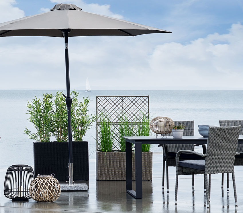 Patio with an upright parasol, lanterns and planter boxes