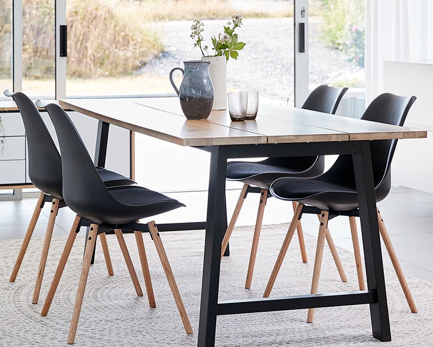 Four black dining chairs at a dining table 