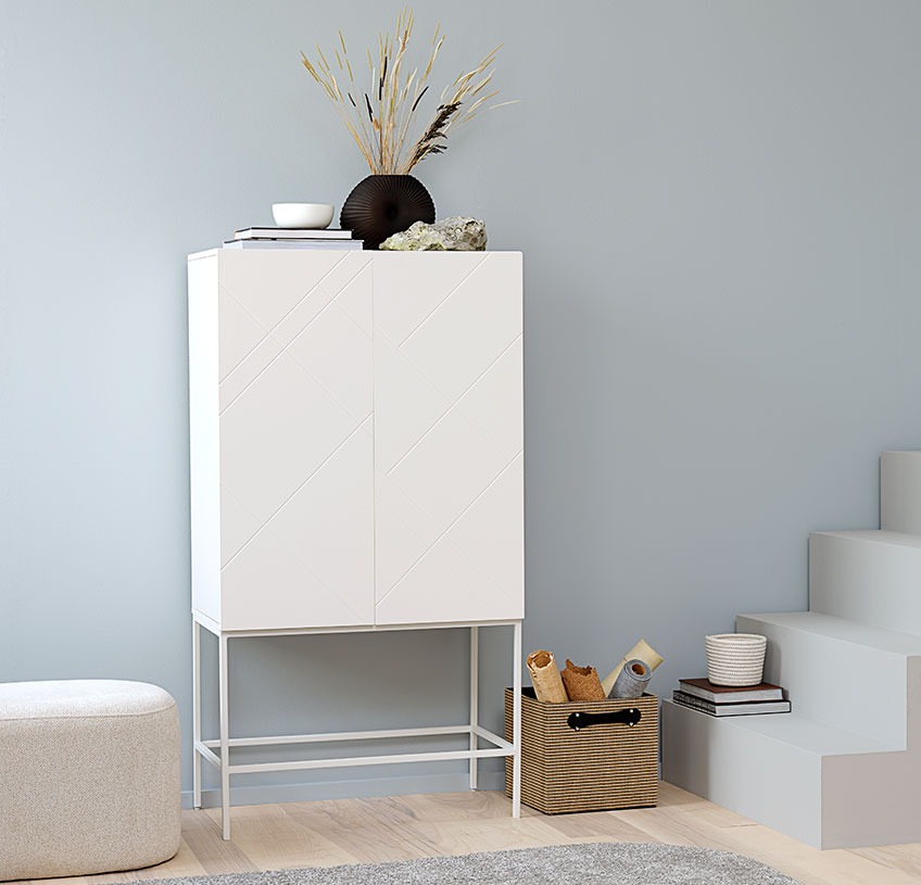 LADBY cabinet with the off-white pouffe OREBO and a FREJ jute basket White cabinet with a black vase and other décor, a white pouffe and a storage basket in jute
