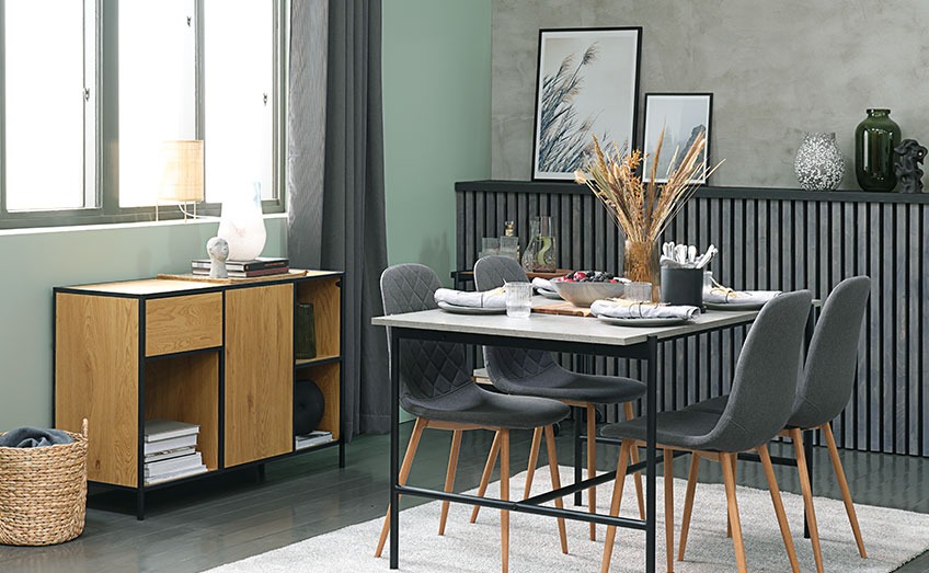 Living room with dining table with concrete-look, grey dining chairs and an oak sideboard 