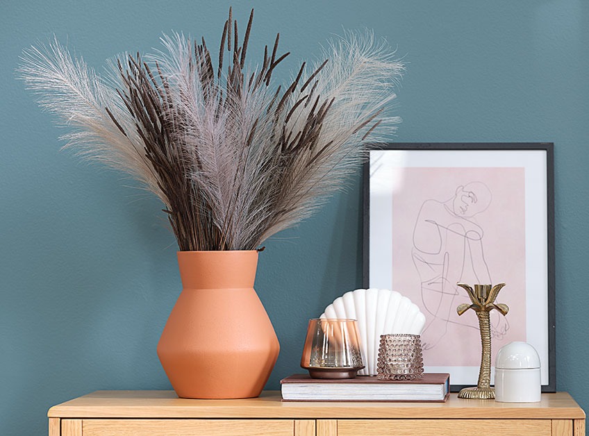 Vase with artificial flowers on a chest of drawers 