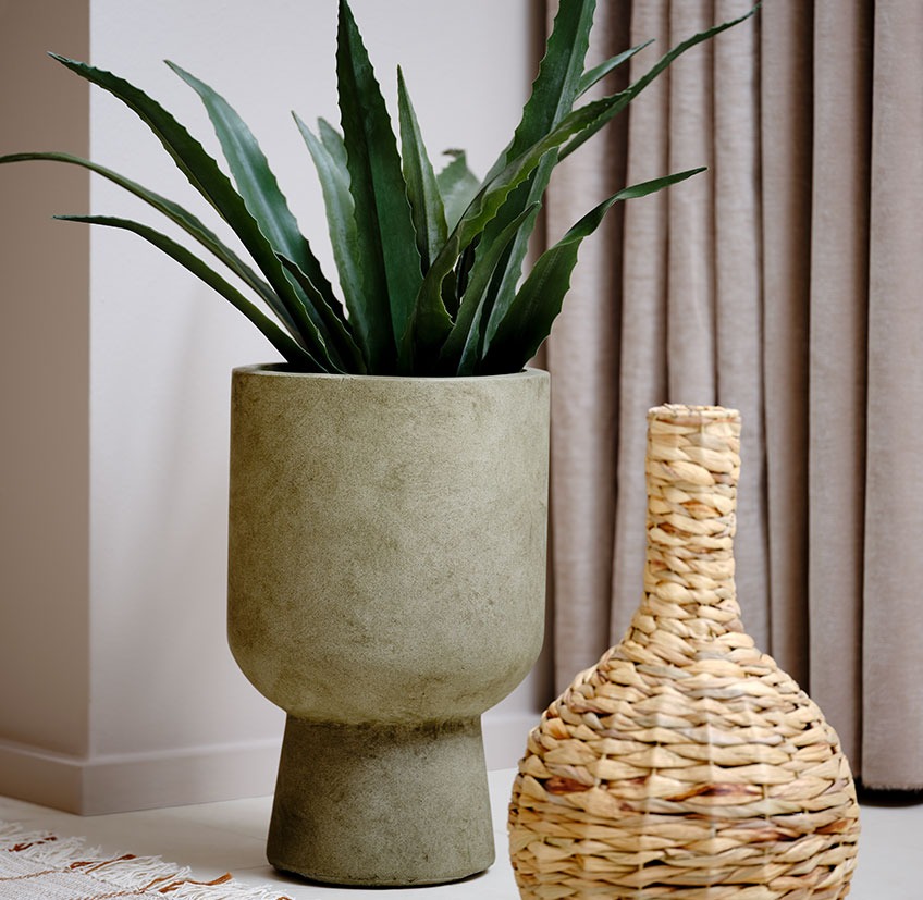 SOLVI plant pot with CELIUS artificial plant next to BJERKE wicker vase Green plant pot with artificial plant next to a wicker vase