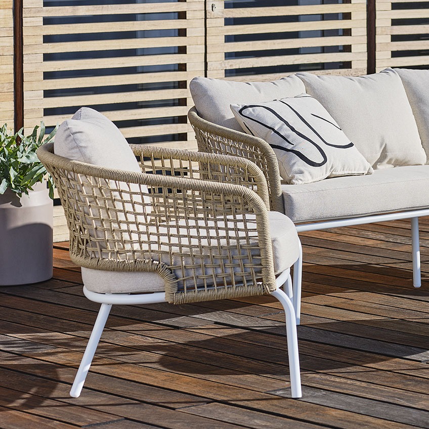 Quick-dry lounge chair in natural coloured wicker and off-white cushions