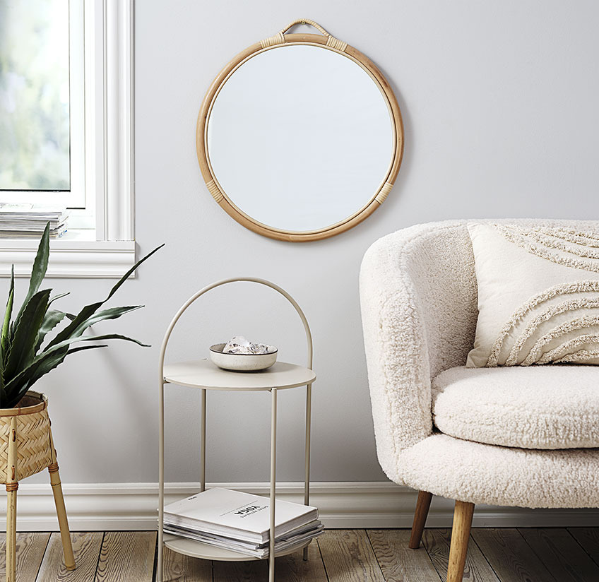 Round mirror above an end table